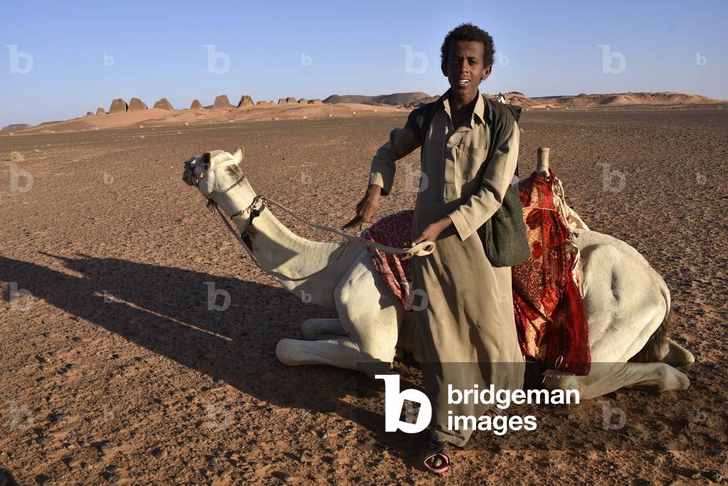 Africa, sudan, nubia, nomad with dromedary, pyramids of meroe in background ©Antonelli Maria Laura/AGF/Leemage