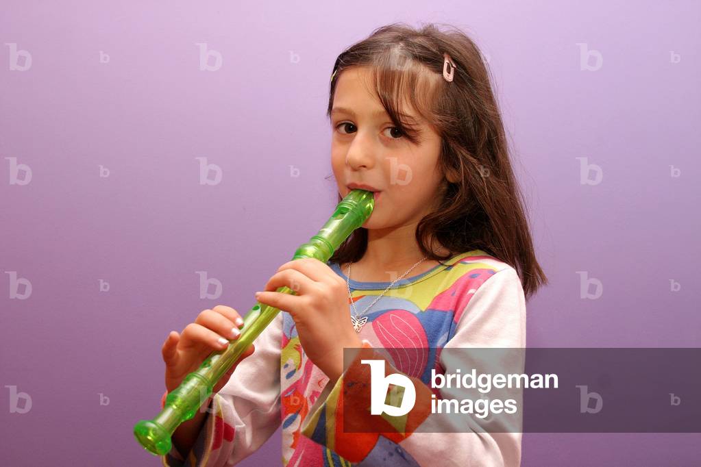 Young girl playing recorder
