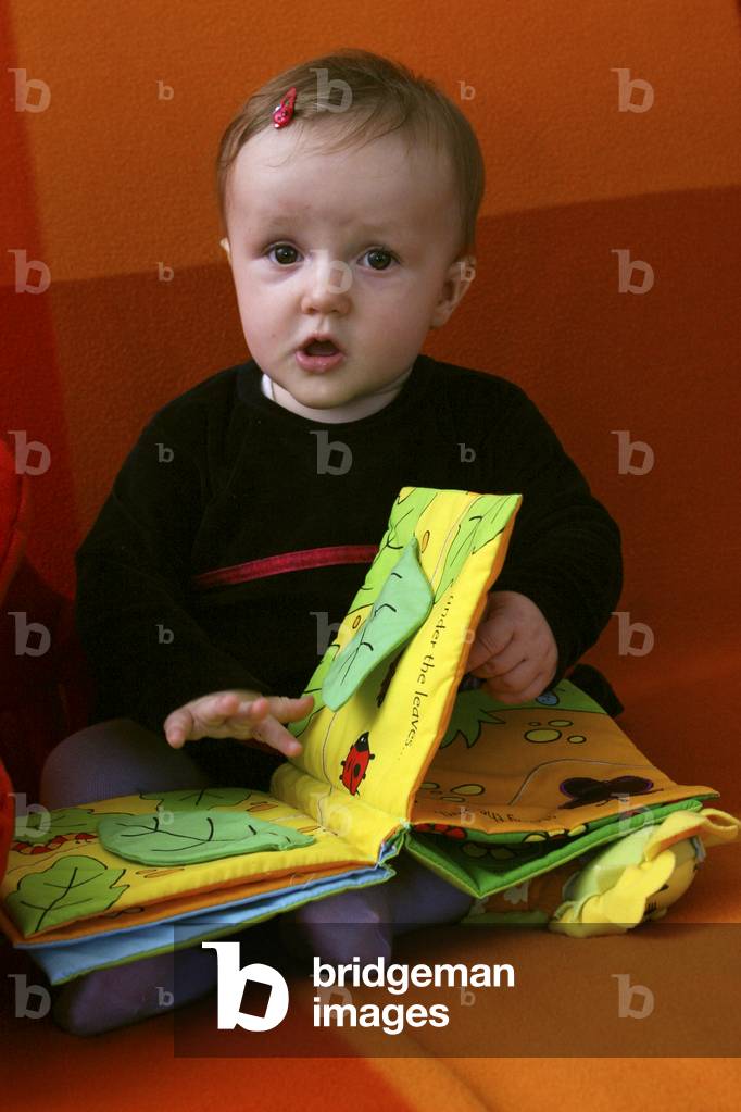 Baby reading a cloth book.