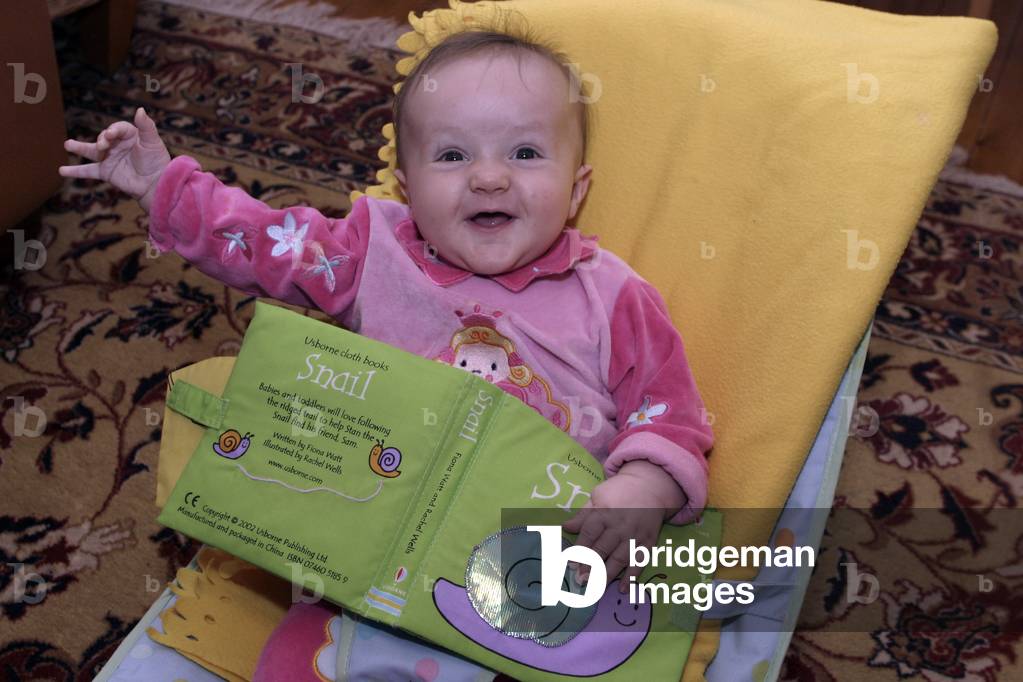 Baby reading her first book at five months. Tara Dujmovic.