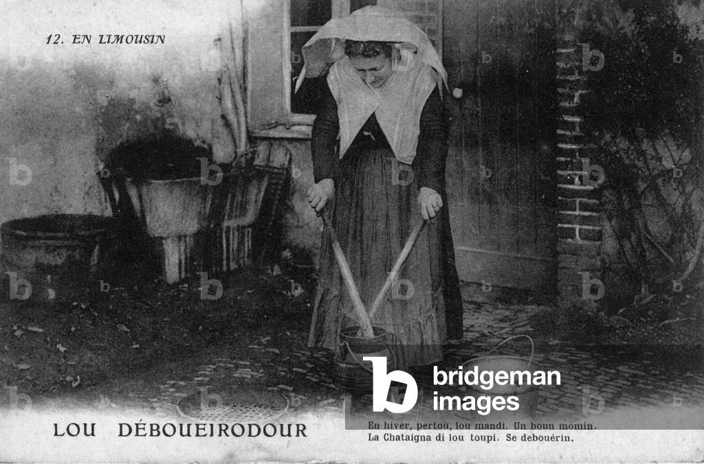 Resident of Limousin: lou deboueirodour. A woman in traditional clothing is cooking a regional dish. Postcard, 20th century.