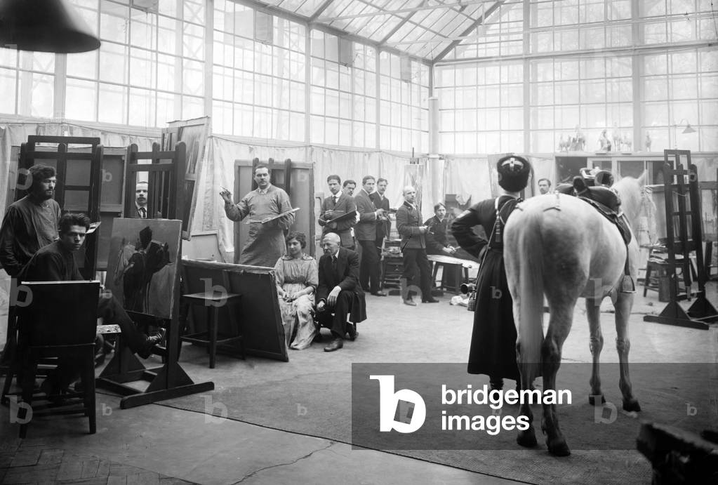 A Cossack and his horse pose for art students in the class of Professor Semionovich-Samokish, a specialist in military themes, Academy of Arts, St. Petersburg (b/w photo)