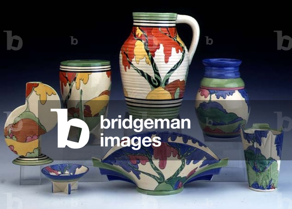 (LtoR) A 'Honolulu' pattern flanged vase, vase and Lotus Jug and a 'Rudyard' pattern vase, conical candlestick, Daffodil vase and small vase by Clarice Cliff (1899-1972) (ceramic)