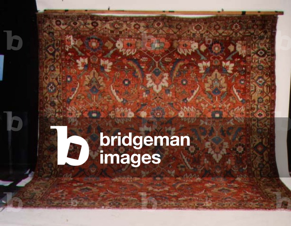 Heriz Carpet, the terracotta field having an all over design of large palmettes and scrolling leaves, enclosed by pale saffron samovar borders