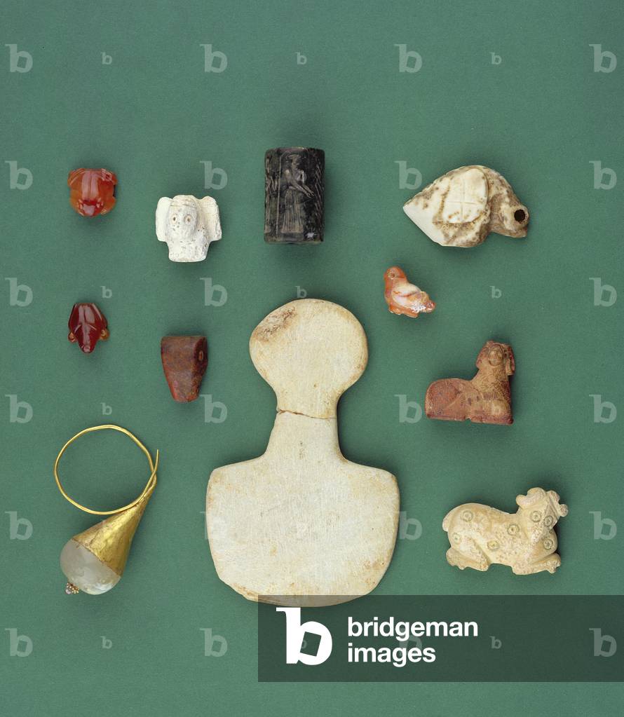 Collection of Eastern Mediterranean objects including a Sumerian vulture amulet, an Akkadian serpentine seal and a Mesopotamian carnelian frog, ranging from 3300-2000 BC