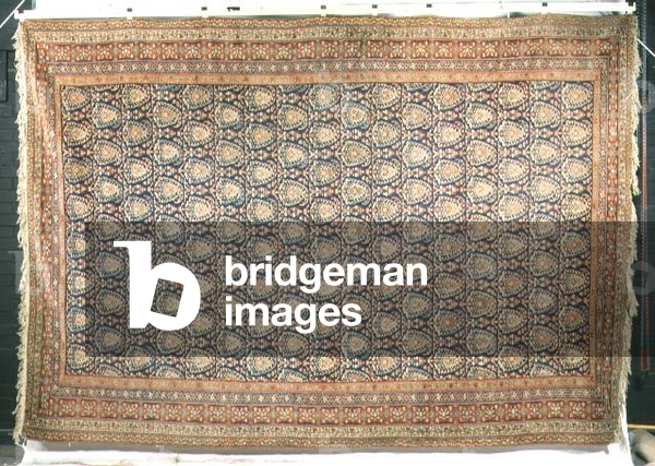 Persian carpet with madder floral meander borders surrounding an indigo field with stylised boteh design, from Feraghan