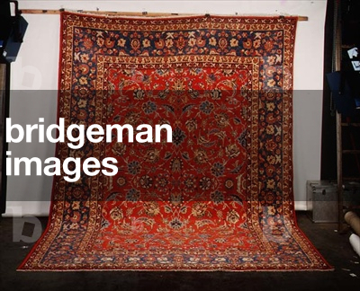 Isfahan Carpet, the brick-red field with an all over design of palmettes with scrolling leafy vines enclosed by pale indigo borders of birds in flight and meandering vines between sinilar guard stripes
