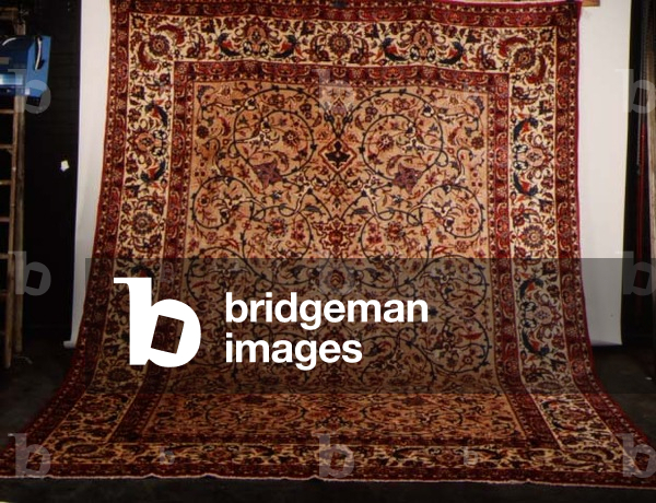 Sarouk Carpet, the mushroom coloured field with an over all design of scrolling floral vines and palmettes, enclosed by wide ivory bird and flower meander borders between leafy guard stripes
