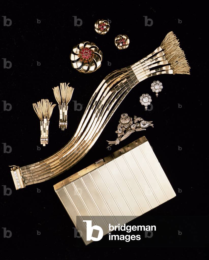 Selection of Art Deco jewellery: Cartier gold vanity case/cigarette holder; gold jarettiere bracelet and earrings; flowerhead brooch and earrings