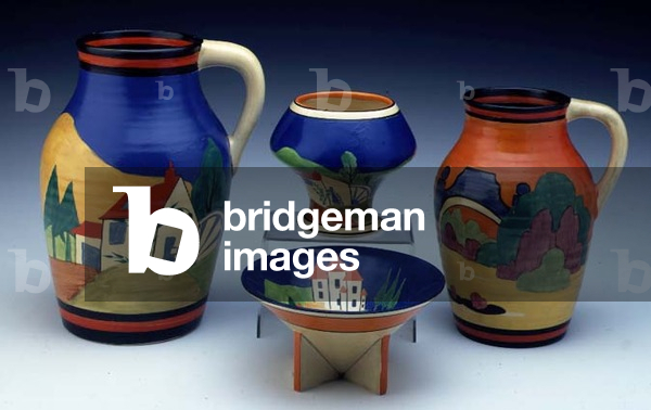 (LtoR) An Applique 'Blue Lugano' single handled Lotus jug and vase, an Applique 'Avignon' pattern single handled Isis jug and an Applique 'Blue Lucerne' conical bowl, by Clarice Cliff (1899-1972) (ceramic)