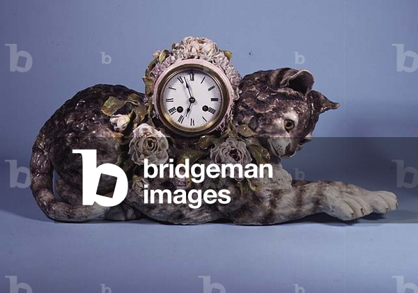 Porcelain figure of a cat, surmounted by a clock, encrusted with a spray of roses, c.1910