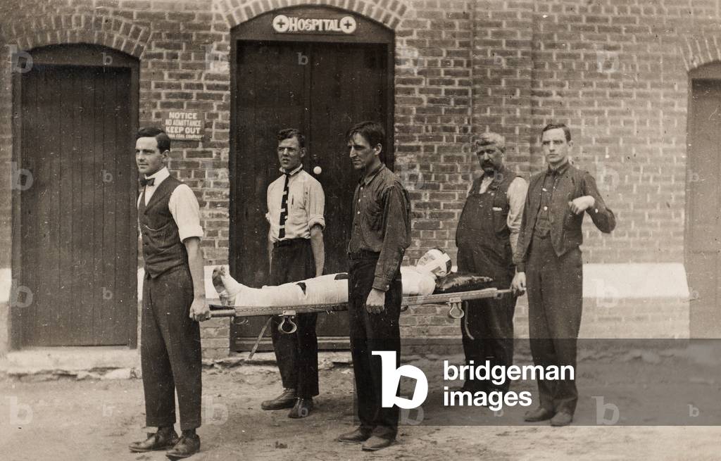Five Men Carry a Heavily Bandaged Man on a Stretcher, Pittston, PA, 1914 (postcard)