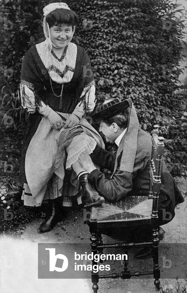 A man looking for a flea on the leg of a woman, Brittany (France) postcard, c. 1900-1910