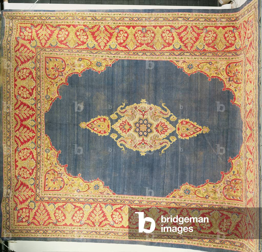 Tapis avec médaillon central dans un champ indigo encadré par des spandrels coussins et des bordures de vigne 