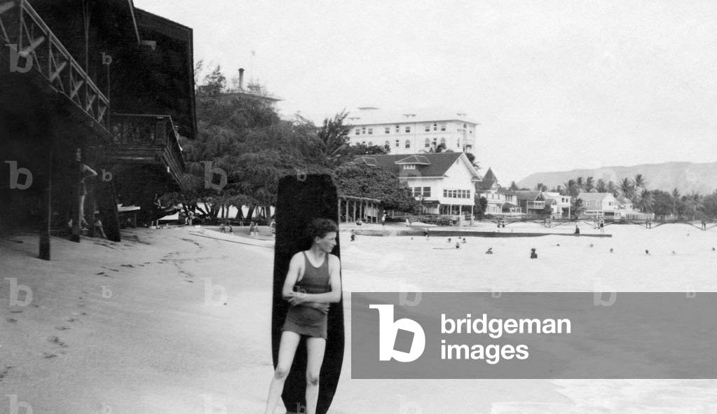 Clarence Welch with surfboard at Waikiki Beach, c.1940s (b/w photo)