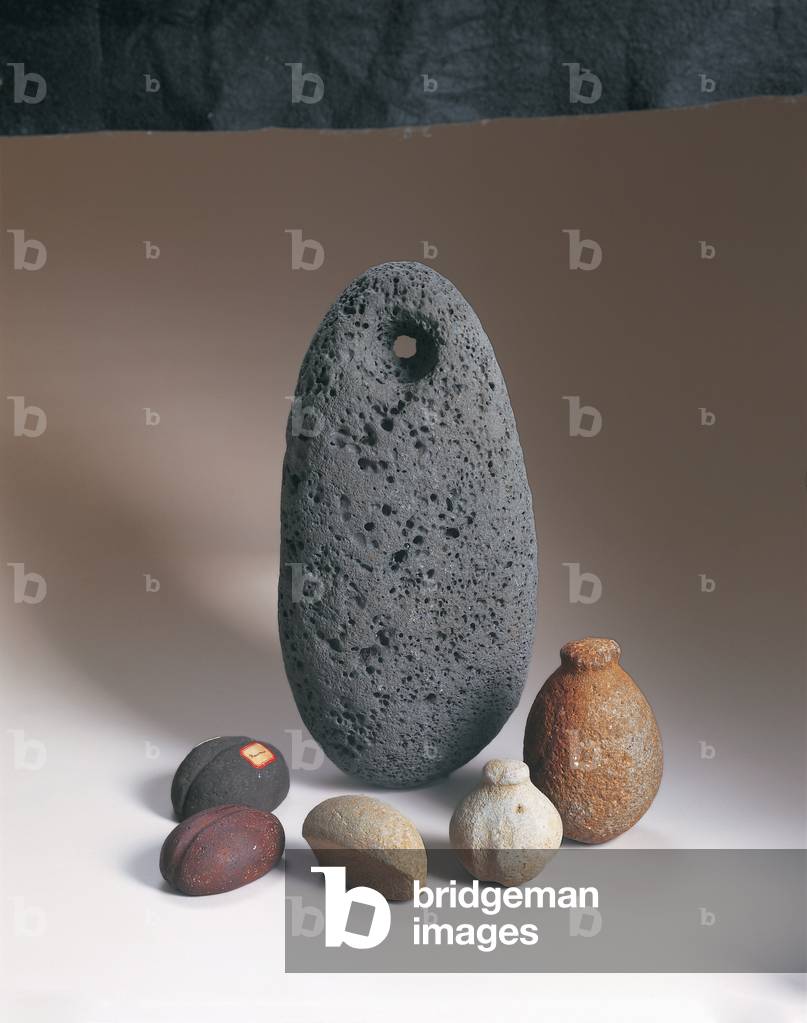 anticlockwise from back: Pohaku hekau, anchor, 18th or early 19th century (basalt), Pohakialoa, plummet sinker, 18th century (basalt), Pohakialoa, plummet sinker, 18th century (basalt), Breadloaf sinker, 18th century (basalt), Grooved sinker, 18th or early 19th century (basalt), Grooved sinker, 18th or early 19th century (basalt)