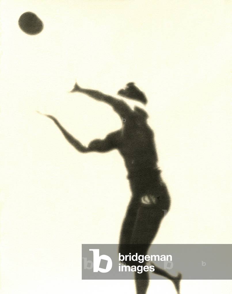 A man playing volleyball on Waikiki Beach (b/w photo)
