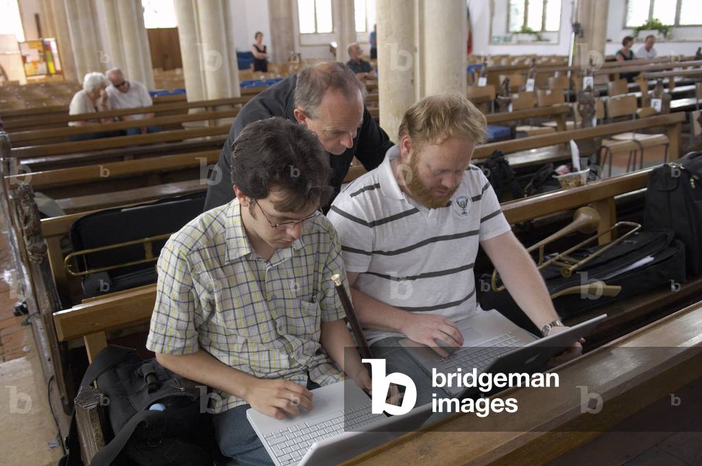 Musicians reading score on their laptops in Blythburgh church, Aldeburgh Festival, Suffolk, UK, June 2007