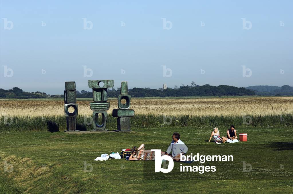 Snape Maltings - view from the grounds     with people relaxing and the Hepworth sculpture in the background