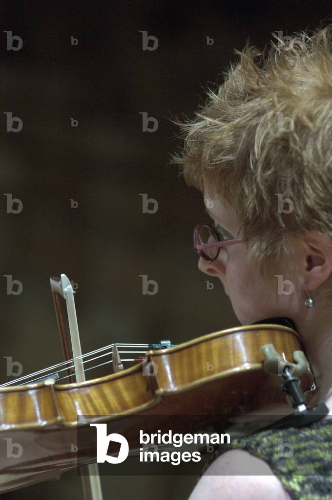 An orchestral violinist performing with the Britten-Pears orchestra in Snape Maltings at the Aldeburgh Festival, 1 June 2005