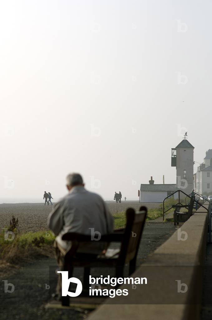 Aldeburgh - view of the sea and beach with a man sitting in the foreground in the town of Aldeburgh in the east of England, 15th October 2005