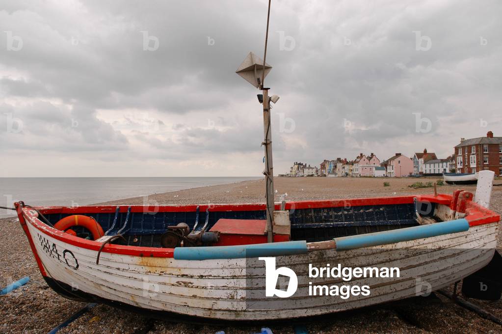 Aldeburgh, view of the beach and sea  with a boat in the foreground on the shore and houses in the near distance