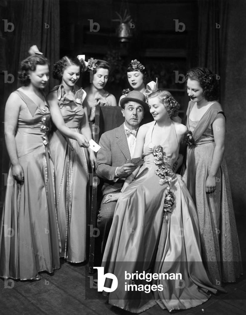 Lupino Lane - British actor - portrait as Bill Snibson in musical 'Me and My Girl' with girls - Victoria Palace, 16 December 1937 - by L