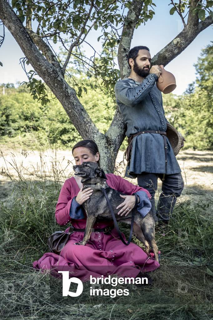 A moment of rest in the shade of a tree, pampering the dog prorpio, Daily life early 15th century, Northern Italy, Piedmont, Italy (photo)