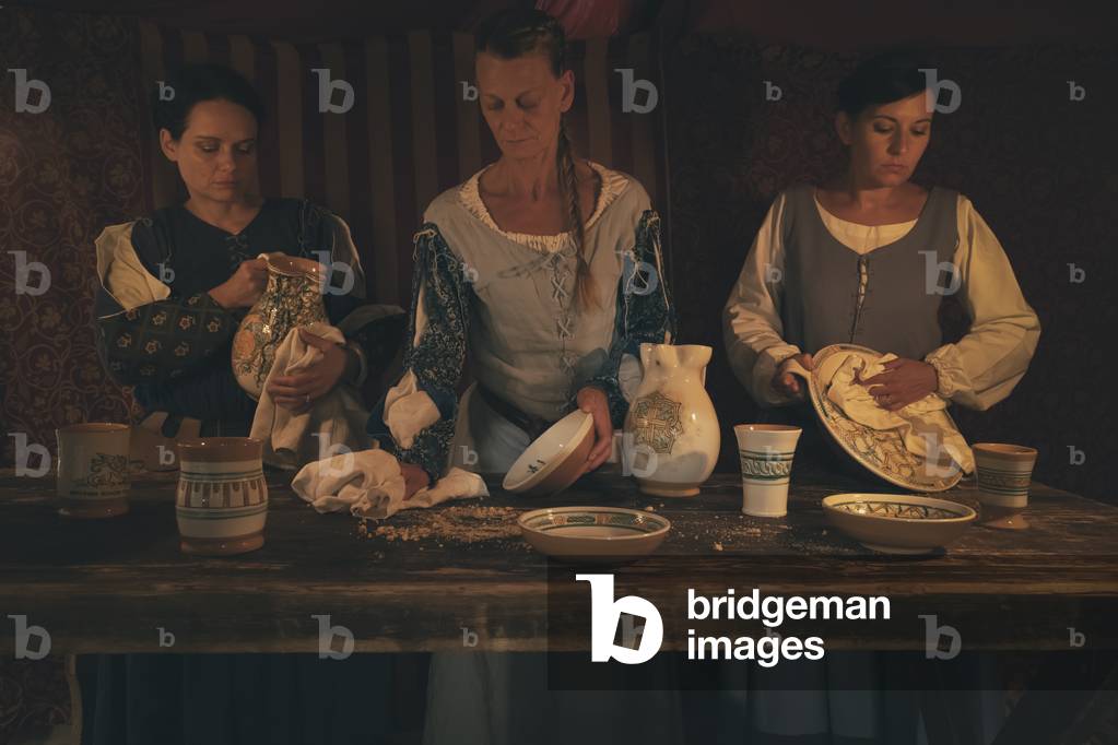 At the end of the dinner, the dishes are cleaned, hypothesis reconstructive uses and customs Middle Ages Italy, Mondaino, Italy (photo)
