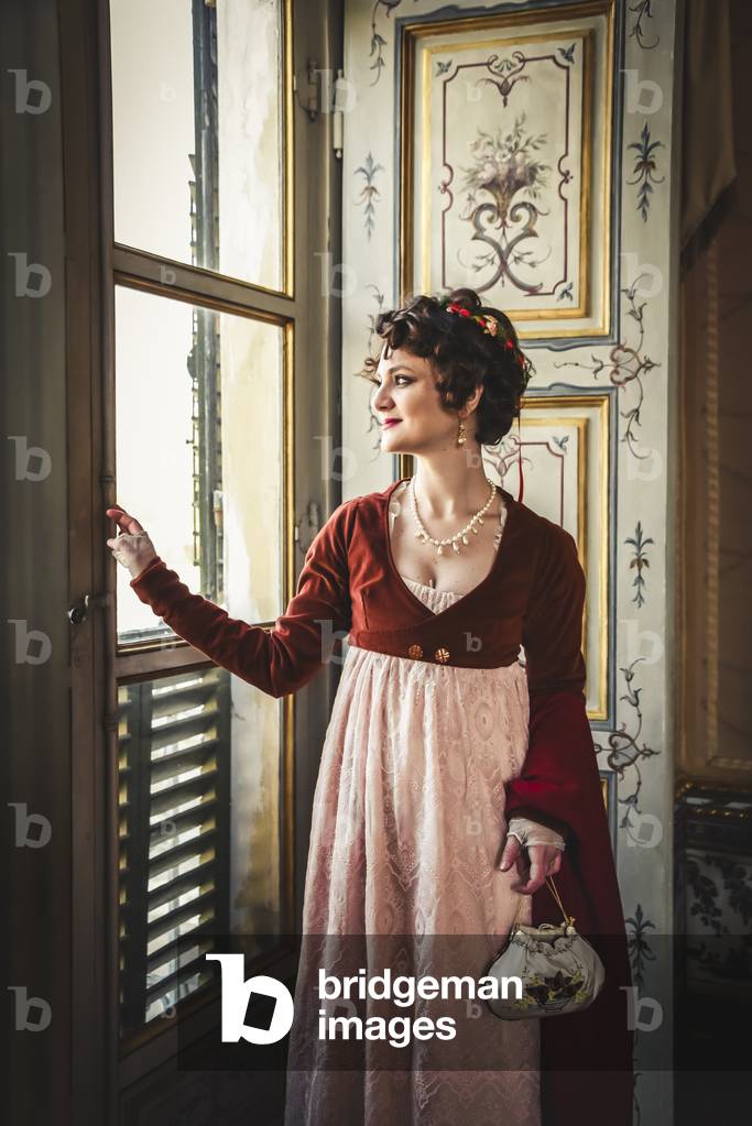 At the court of Napoleon: portrait of noblewoman in red dress at the window, Niichelino, Piedmont, Italy (photo)