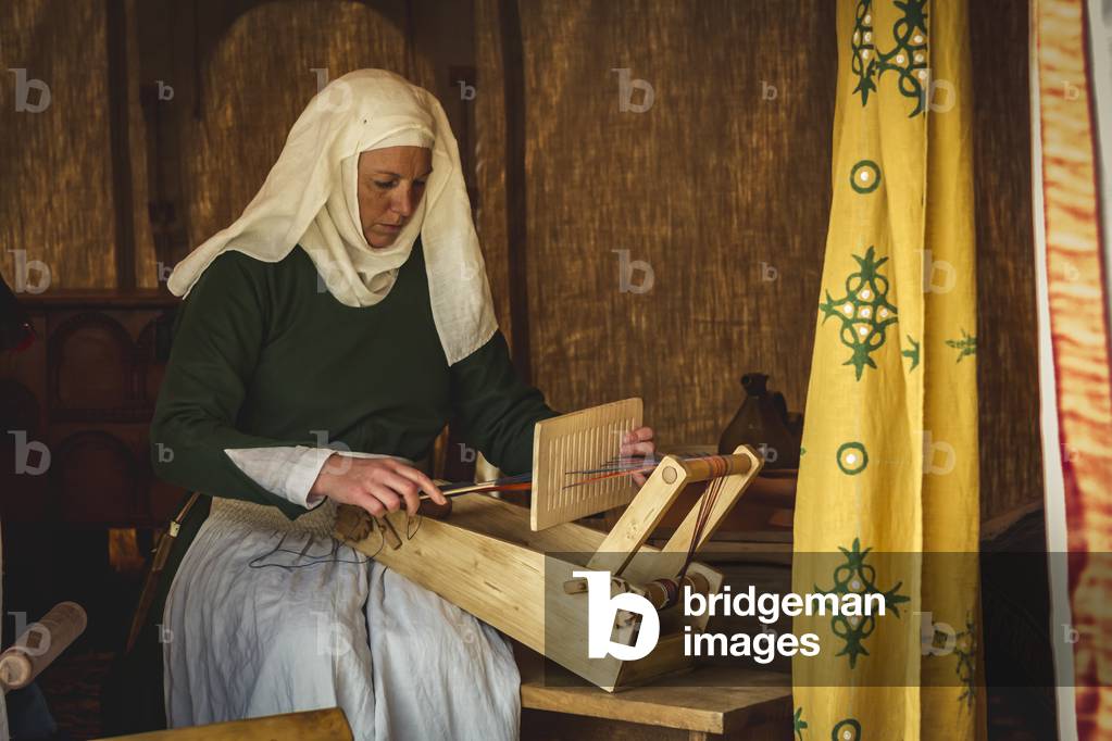 Reconstructive hypothesis of uses and customs, arts and crafts 14th century: Inside the tent we work on the loom, Villafranca di Verona, Veneto, Italy (photo)