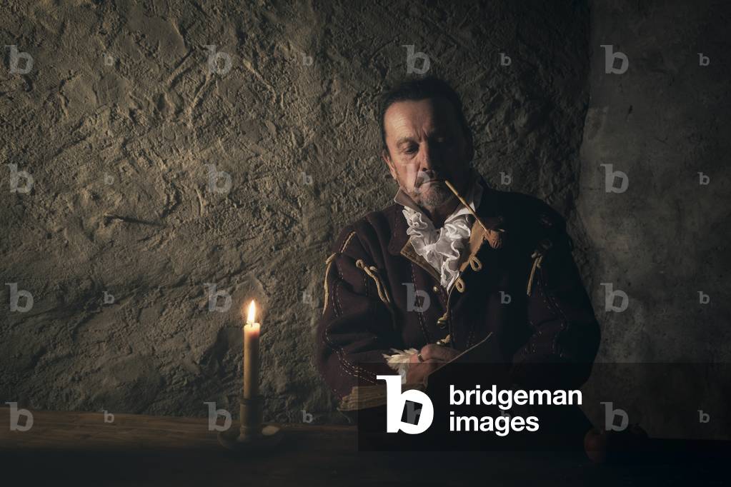 17th century, North Italy: country militia. Reconstructive hypothesis civil and military uses and customs. The captain, sitting at the table, notes the events of the day in his diary, Verrua Savoia, Turin, Piedmont, Italy (photo)