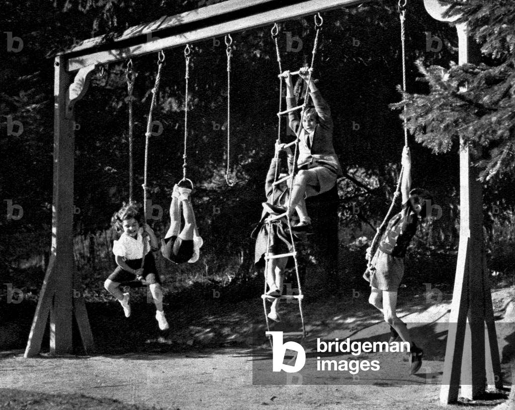 Children playing at rope and swings, 1952 (b/w photo)