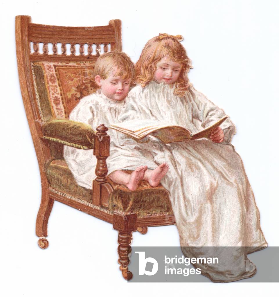 A Victorian Die-cut shape card of two children sitting on an armchair looking at a book, c.1880 (colour litho)