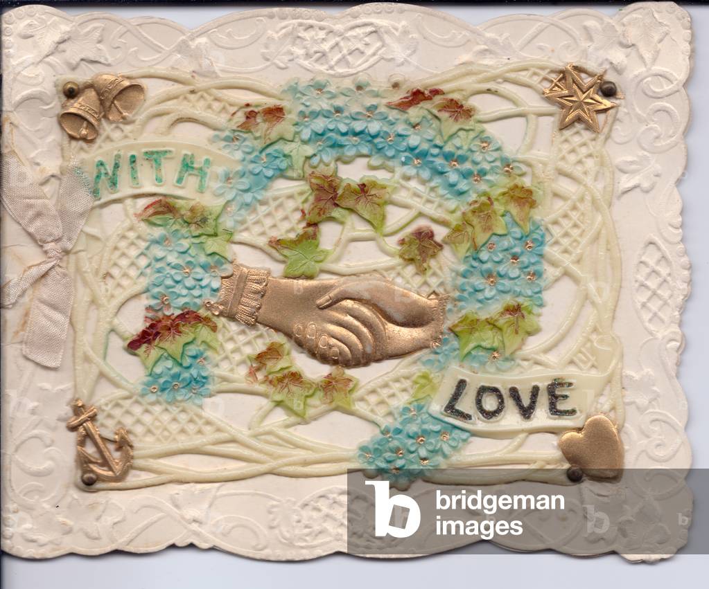 A valentine card made of plastic with clasping hands and a floral horseshoe, entittled 'with love', circa 1910 (plastic)