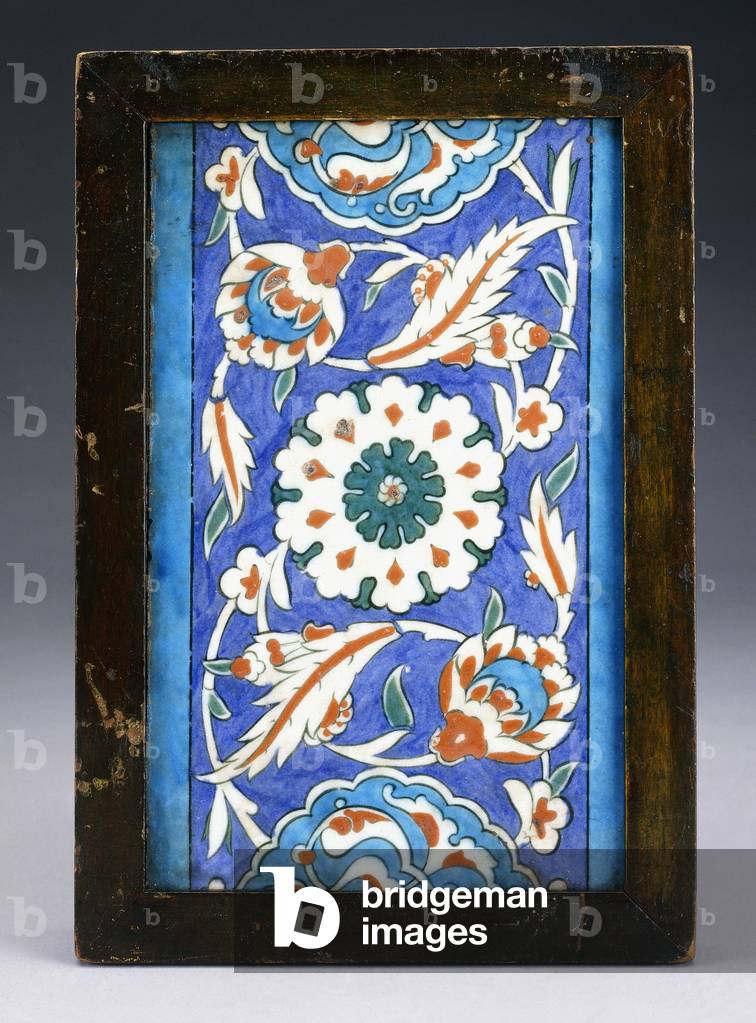 An Iznik border tile, with a central flowerhead between scrolling palmette and leafy vine, c.1570 (ceramic)