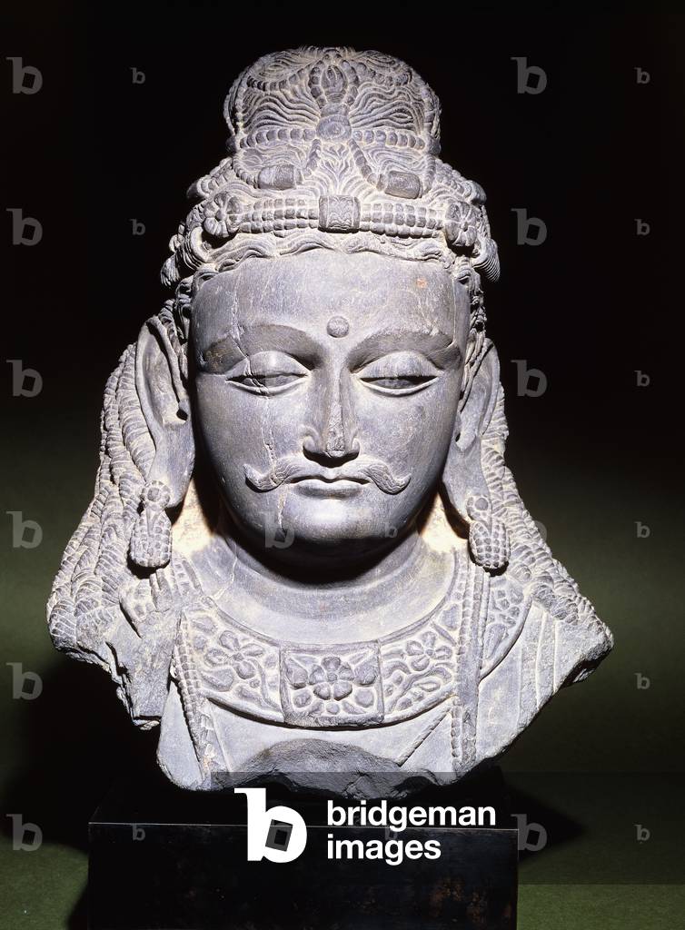 A large head of a Bodhisattva with a downcast expression, 2nd-3rd century (grey schist, metal block base)