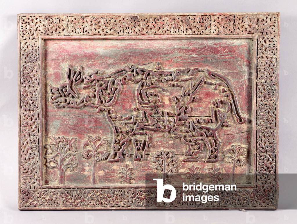 An Indian carved and applied decorative inscription panel, the inscription formed in the shape of a hippopotamus,  (wood, painted in green and carmine)