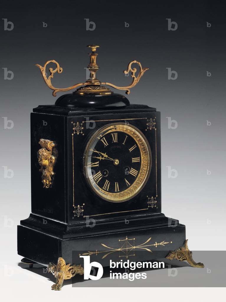 A mantle clock of black composition stone, with incised decoration, with legs, finials and fittings in gilt brass, by Jausions of Pau, France, c.1876-78 (black composition stone, with incised decoration, with legs, finials and fittings in gilt brass)