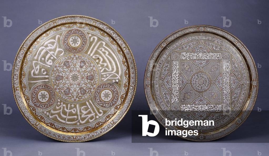 Two gold, copper and silver inlaid brass circular trays, decorated with arabesques and inscriptions, late 19th century (gold, copper and silver inlaid brass)