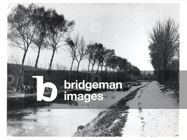 Horses pulling barges on a canal (b/w photo)