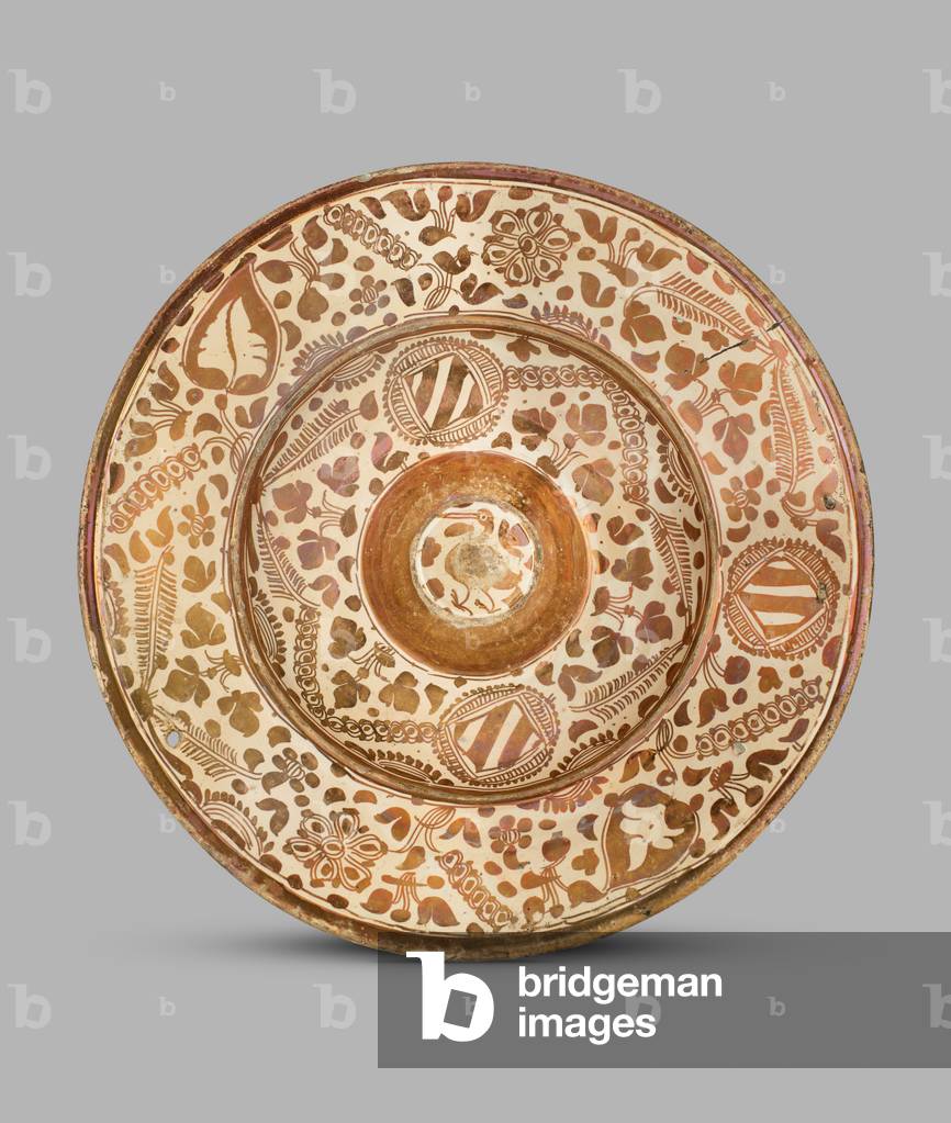 Dish decorated in lustre with leaves and flowers and diamond 
shaped panels, the solid lustre raised boss decorated with a bird
, 1525-60 (tin-glazed lustred ceramic)