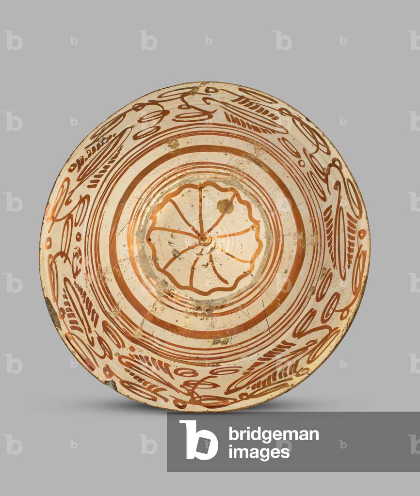 Dish decorated in lustre with leaves and flowers and diamond 
shaped panels, the solid lustre raised boss decorated with a bird
, 1525-60 (tin-glazed lustred ceramic)