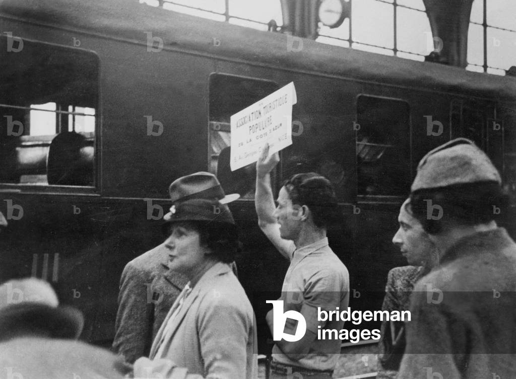 First paid leaves in France in 1936 : member of a touristic association of the Riviera waiting for the tourists at the railway station