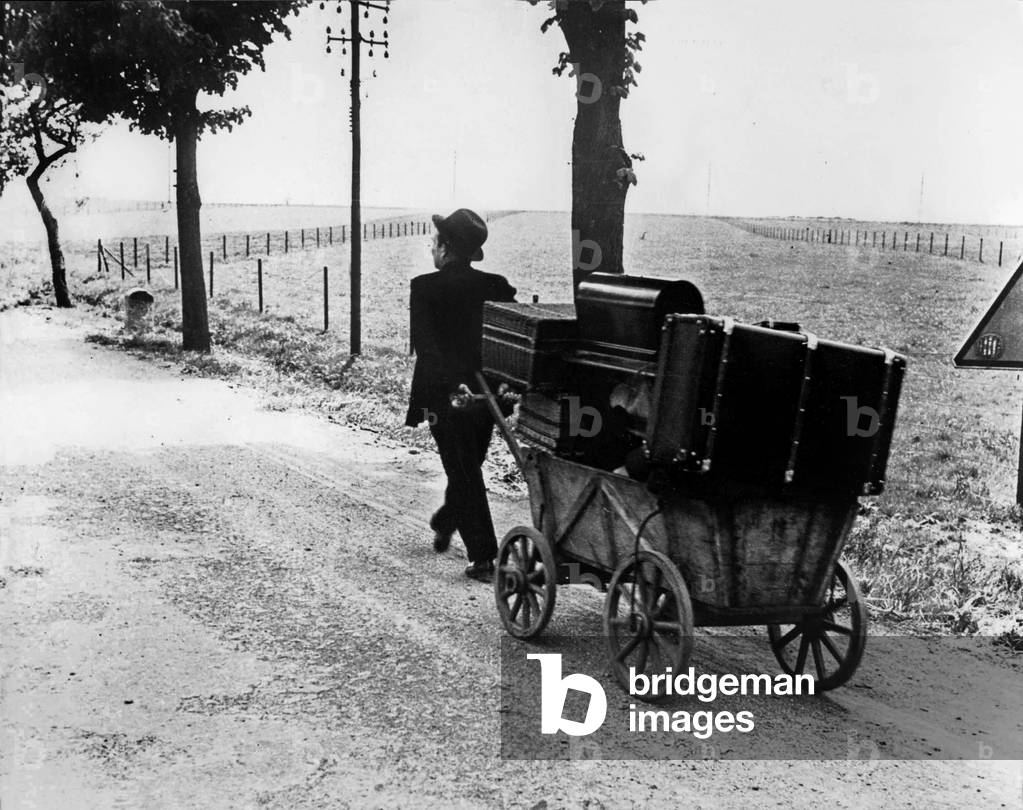 Exodus in France : a man with luggage on the road to escape German invasion in France from june 1940