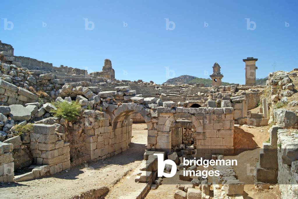 View through the vaulted entrance of the Xanthos theatre into the Orchestra pit, showing pillar and Harpy tomb, Xanthos, Turkey (photo)