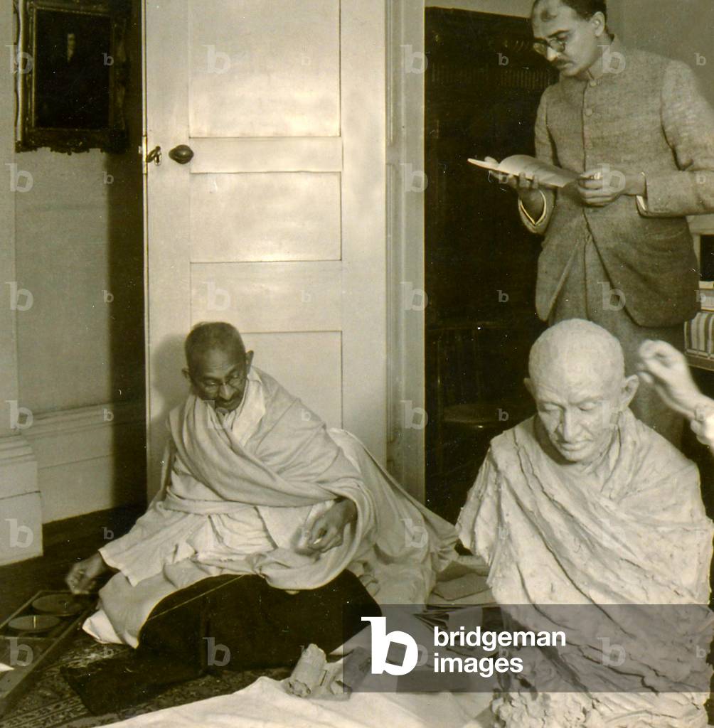 Mohandas Karamchand Gandhi (1869 – 1948) sitting for a sculptor. (photo)