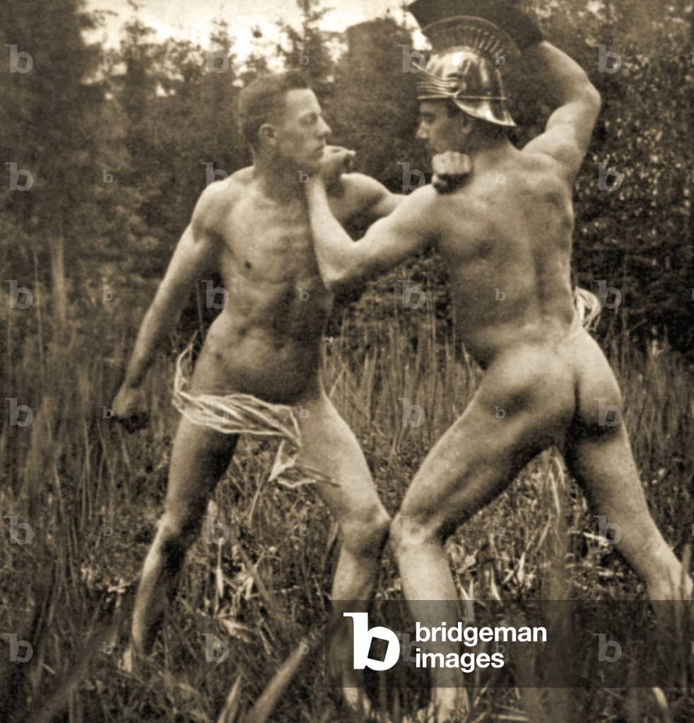 Fighting/battle pose with a Roman Helmet, c.1910 (sepia photo)