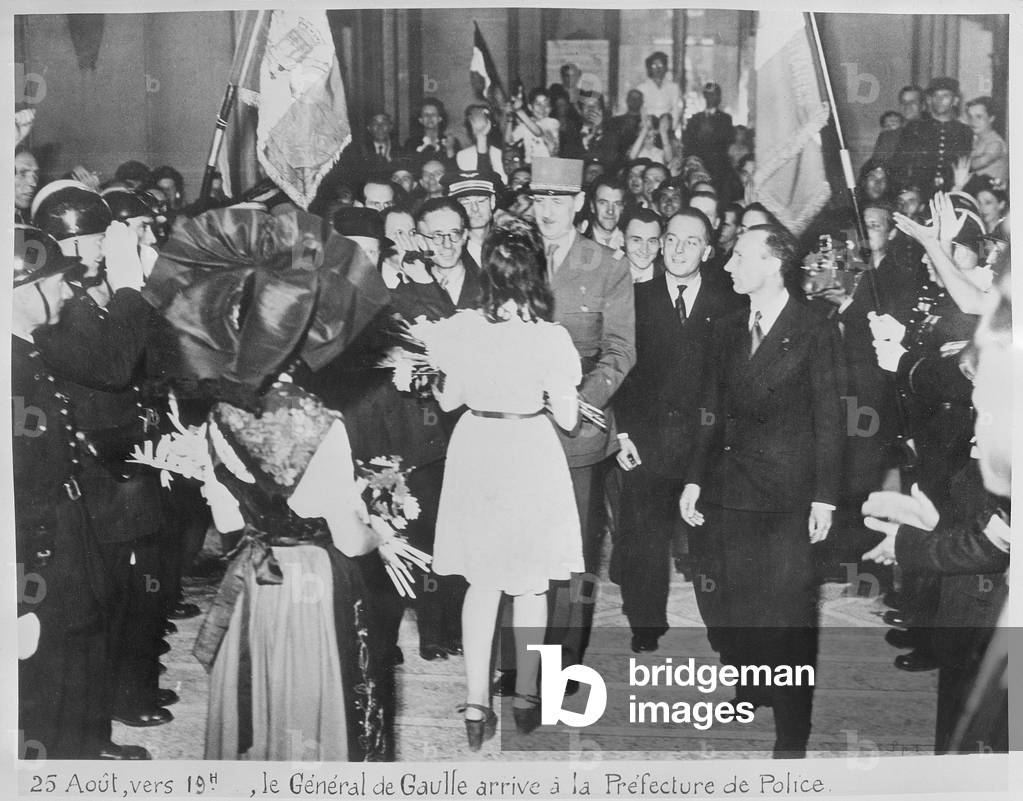 Liberation of Paris, a young woman offering a bunch of flowers to General Charles de Gaulle (1890-1970) when arriving to the Police Headquarters around 7 pm, 25th August 1944 (b/w photo)