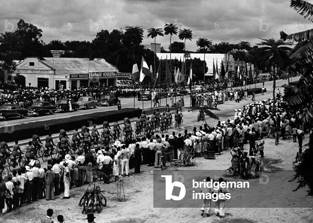 Cyclists of the Belgian Congo Army cycling before Charles de Gaulle on an official visit to Leopoldville, 21 March 1953 (b/w photo)